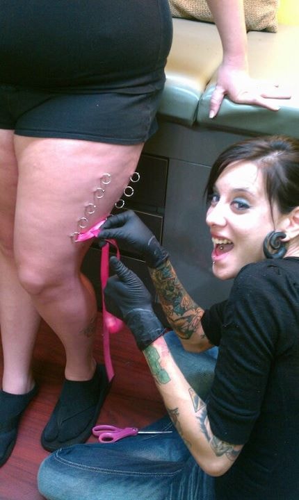 Navel piercing alongside flower and stars tattoo