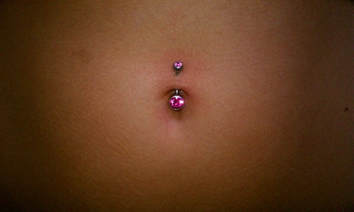 Double navel piercing with pink gem jewelry